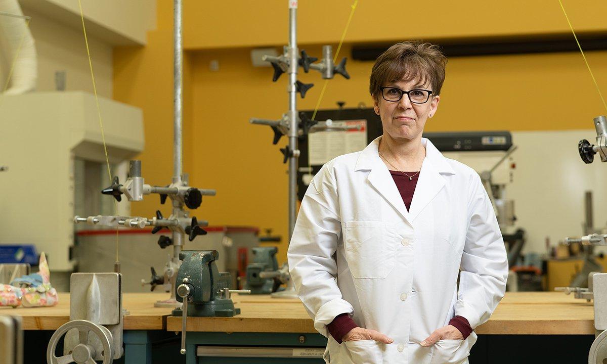 Woman wearing lab coat with hands in pockets