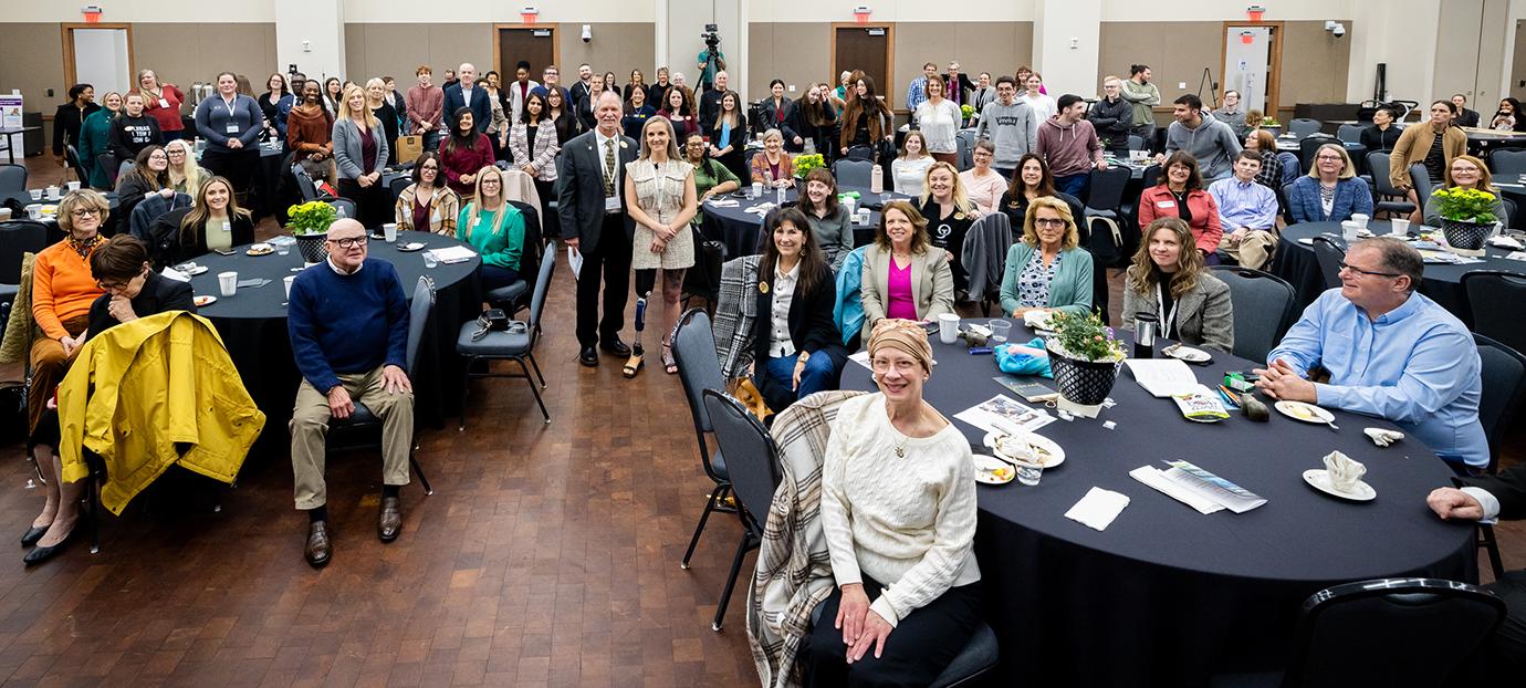 A crowd sitting at tables in a banquet room