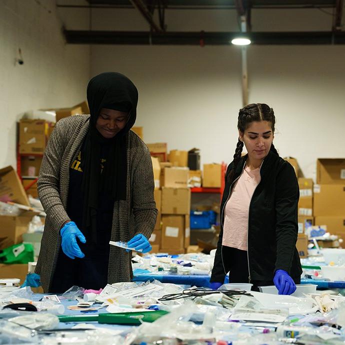 Two women sorting through medical equipment