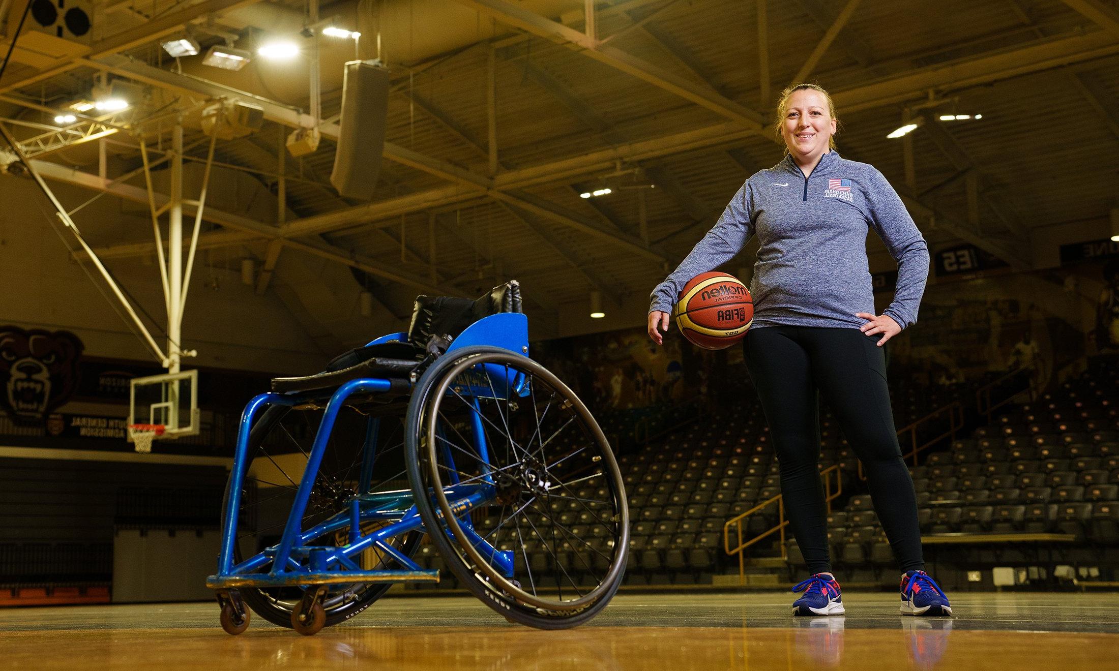 A person with a basketball standing next to a wheelchair